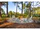 Outdoor fire pit with Adirondack chairs surrounded by trees, providing a relaxing and serene setting at 5208 Holly Forest, Hollywood, SC 29449