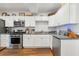 A modern kitchen with white cabinets, stone countertops, and stainless steel appliances at 5208 Holly Forest, Hollywood, SC 29449