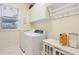 Functional laundry room with white cabinets, shelving, and modern washer and dryer at 5208 Holly Forest, Hollywood, SC 29449
