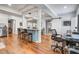 Open-concept living space with kitchen island, hardwood floors, and abundant natural light at 5208 Holly Forest, Hollywood, SC 29449