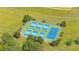 Aerial view of pristine tennis courts surrounded by lush greenery and well-maintained landscaping at 5208 Holly Forest, Hollywood, SC 29449