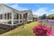 Exterior shot highlighting brick accents, sunroom, and colorful flowers at 5286 Waterview Dr, North Charleston, SC 29418