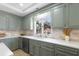 Charming kitchen featuring gray cabinets, light countertops, tile backsplash and window above sink at 5286 Waterview Dr, North Charleston, SC 29418