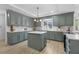 Well-lit kitchen with an island, gray cabinets, modern appliances, and light countertops at 5286 Waterview Dr, North Charleston, SC 29418