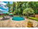 Backyard featuring a private pool, sun loungers, lush landscaping, and a wooden privacy fence at 5556 Indigo Fields Blvd, North Charleston, SC 29418