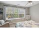 Cozy bedroom featuring a large window, ceiling fan, neutral walls and comfortable furnishings at 5556 Indigo Fields Blvd, North Charleston, SC 29418
