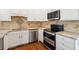 Well-equipped kitchen featuring granite countertops and white cabinets with stainless steel appliances at 5556 Indigo Fields Blvd, North Charleston, SC 29418