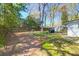 Spacious backyard featuring a wooden fence, large trees, a shed, and a grill at 5801 Chaucer Dr, Hanahan, SC 29410