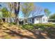 View of the home's backyard with a shed, grill, firepit, and a lush, green lawn at 5801 Chaucer Dr, Hanahan, SC 29410