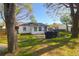 Backyard showcasing the home's exterior, a covered grill, and mature shade trees at 5801 Chaucer Dr, Hanahan, SC 29410