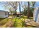 View of backyard featuring a storage shed, grill, mature trees, and lush green grass at 5801 Chaucer Dr, Hanahan, SC 29410