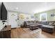 Open-concept living area with large sectional couch, light walls, and gleaming wood-look floors at 5801 Chaucer Dr, Hanahan, SC 29410