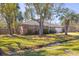 A charming single-story brick home with a well-maintained lawn and mature trees by a small creek at 689 Port Cir, Charleston, SC 29412