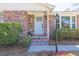 Close-up of a charming brick home's entrance with a light blue door, adorned with blooming flowers at 689 Port Cir, Charleston, SC 29412