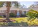 Charming brick home with a well-manicured lawn and mature palm trees in a sunny front yard at 689 Port Cir, Charleston, SC 29412