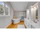 Bright bathroom featuring a standalone tub, white cabinets, dual vanity sinks, and hardwood floors at 7 Guerard Rd, Charleston, SC 29407