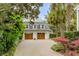 Detached two-car garage with wooden doors and brick driveway, surrounded by lush greenery at 7 Guerard Rd, Charleston, SC 29407