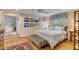 Well-lit main bedroom with wood floors, an upholstered bed, and access to the bathroom at 7 Guerard Rd, Charleston, SC 29407