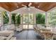 Charming screened porch with wicker furniture, ceiling fan, and views of the backyard at 7 Guerard Rd, Charleston, SC 29407