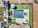 Aerial view of a modern backyard with a sparkling pool, spa, lush landscaping, and outdoor seating, perfect for relaxation at 7858 Gull Bay Dr, Awendaw, SC 29429