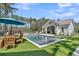 Beautiful backyard with a pool, spa, outdoor dining area, and artificial turf, perfect for entertaining and relaxation at 7858 Gull Bay Dr, Awendaw, SC 29429