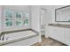 Bright bathroom with tub, white cabinets, vanity and marble tile flooring at 7858 Gull Bay Dr, Awendaw, SC 29429