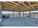 Spacious covered dock featuring wood plank flooring, ideal for outdoor entertaining and enjoying waterfront views at 7858 Gull Bay Dr, Awendaw, SC 29429