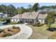 Attractive single-story home featuring a circular driveway, neatly manicured landscaping, and an inviting front entrance at 7858 Gull Bay Dr, Awendaw, SC 29429