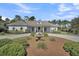 Beautiful home with a circular driveway, manicured landscaping, and a charming water feature enhancing its curb appeal at 7858 Gull Bay Dr, Awendaw, SC 29429
