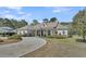 Attractive single-story home with a circular driveway, well-maintained landscaping, and a welcoming front porch at 7858 Gull Bay Dr, Awendaw, SC 29429