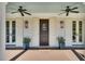 Charming front porch with double doors, stylish lighting, and potted plants at 7858 Gull Bay Dr, Awendaw, SC 29429
