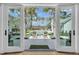 Stunning outdoor pool area with lounge chairs and lush landscaping viewed from open doors at 7858 Gull Bay Dr, Awendaw, SC 29429