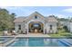 Relaxing pool house featuring an outdoor fireplace, TV, and comfortable seating near the pool at 7858 Gull Bay Dr, Awendaw, SC 29429