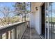 A spacious balcony with wooden railings and privacy fence with a view of trees and the street at 7875 Sandida Ct, North Charleston, SC 29418