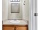 Functional half bathroom with a single sink vanity, framed mirror, and overhead lighting at 7875 Sandida Ct, North Charleston, SC 29418