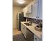 Galley kitchen featuring white cabinets, stainless steel appliances and a mosaic backsplash at 7945 Edgebrook Cir # B, North Charleston, SC 29418
