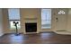 Spacious living room with wood floors, two windows, a fireplace, and a white front door at 7945 Edgebrook Cir # B, North Charleston, SC 29418