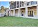A spacious lawn and patio area are featured under a screened in porch on this home's back exterior at 8638 Scottish Troon Ct, North Charleston, SC 29420