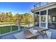 The back porch offers relaxing seating and panoramic views of the backyard and pond with treelined horizon at 8638 Scottish Troon Ct, North Charleston, SC 29420