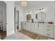 Bright bathroom featuring double sinks, round mirrors, modern fixtures, and chandelier at 8638 Scottish Troon Ct, North Charleston, SC 29420