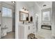 Bright, modern bathroom features a vanity, mirror, and separate toilet area for added privacy at 8638 Scottish Troon Ct, North Charleston, SC 29420