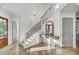 Inviting entryway with hardwood floors, staircase, and decorative mirror on console table at 8638 Scottish Troon Ct, North Charleston, SC 29420