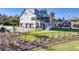 Exterior view of home with a large backyard, two-car garage, and charming architecture at 8638 Scottish Troon Ct, North Charleston, SC 29420