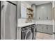 Well-organized laundry room with modern appliances and stylish gray cabinetry at 8638 Scottish Troon Ct, North Charleston, SC 29420
