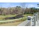 Scenic view of a pond and walking path from the home's deck, framed by trees and lush landscaping at 8638 Scottish Troon Ct, North Charleston, SC 29420