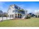 Beautiful rear exterior showcasing a well-manicured lawn and a three-car garage with a charming home at 8638 Scottish Troon Ct, North Charleston, SC 29420