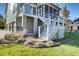 A detailed view of the rear exterior with the staircase and manicured landscaping on a sunny day at 8638 Scottish Troon Ct, North Charleston, SC 29420