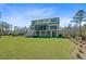 The rear exterior view highlighting the spacious yard, and the home's back porch in a private wooded setting at 8638 Scottish Troon Ct, North Charleston, SC 29420
