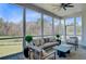 A cozy screened-in porch with comfortable seating offers views of the lush green backyard and surrounding trees at 8638 Scottish Troon Ct, North Charleston, SC 29420