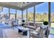 Relax in this comfortable screened-in sunroom with a ceiling fan and stylish outdoor furniture and neighborhood view at 8638 Scottish Troon Ct, North Charleston, SC 29420